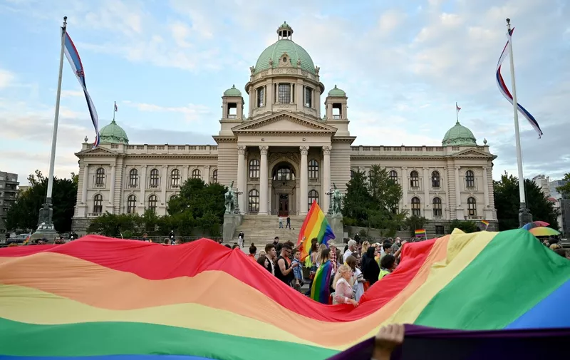People hold a huge rainbow flag in front of the National Assembly building, during the Belgrade Pride march, on September 18, 2021. (Photo by Andrej ISAKOVIC / AFP)