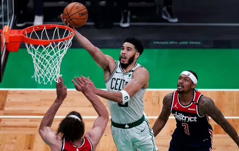 Boston Celtics forward Jayson Tatum drives to the basket against Washington Wizards center Robin Lopez (15) during the second half of an NBA basketball Eastern Conference play-in game Tuesday, May 18, 2021, in Boston. At right is Wizards guard Bradley Beal. (AP Photo/Charles Krupa)