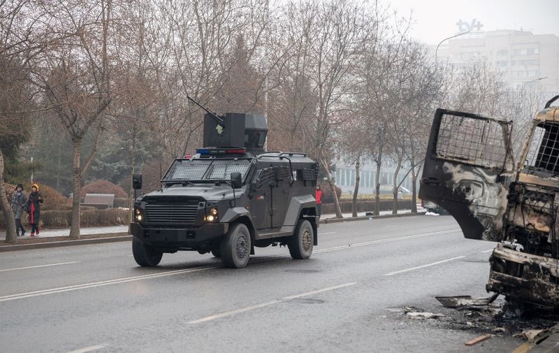 A military vehicle moves along a street in central Almaty on January 7, 2022, after violence that erupted following protests over hikes in fuel prices. - Kazakhstan's president has rejected calls for talks with protesters after days of unprecedented unrest, vowing to destroy "armed bandits" and authorising his forces to shoot to kill without warning. He said earlier that order had mostly been restored across the country, after protests this week over fuel prices escalated into widespread violence, especially in main city Almaty. (Photo by Alexandr BOGDANOV / AFP)