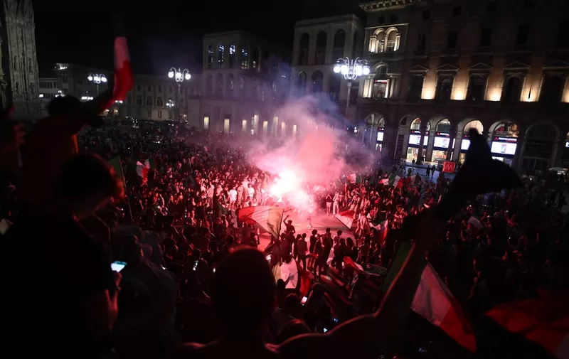 Supporters of the Italian national football team celebrate after Italy beat England 3-2 on penalties to win the UEFA EURO 2020 final football match between England and Italy in Piazza del Duomo in Milan on July 11, 2021. (Photo by Marco BERTORELLO / AFP)