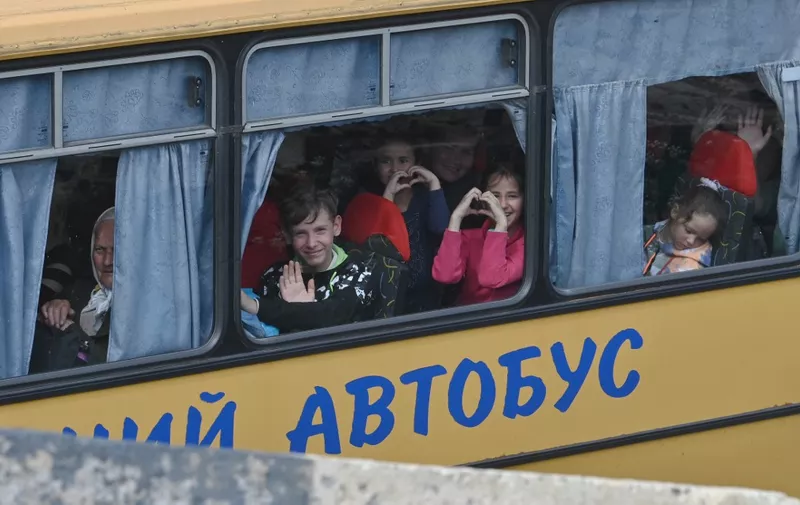 Ukrainian evacuees react in a bus while they drive on a road east of Kharkiv on May 30, 2022, amid Russian invasion of Ukraine. - Over three months after Russia launched its invasion on February 24 and which has left thousands dead on both sides and displaced millions of Ukrainian civilians, Moscow is focusing on the east of Ukraine after failing in its initial ambition to capture Kyiv. (Photo by Genya SAVILOV / AFP)