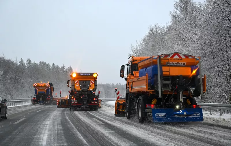 Snow plows clear the A45 highway from snow and ice near Drolshagen, western Germany, on March 15, 2023. (Photo by INA FASSBENDER / AFP)