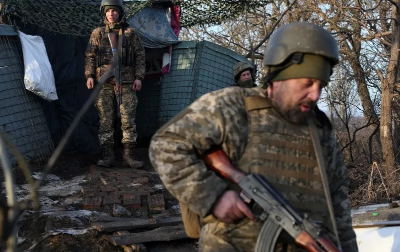 Servicemen of the Ukrainian Military Forces walk on the front line with Russian-backed separatists near Novohnativka, Donetsk region, on February 20, 2022. - OSCE monitors recorded more than 1,500 violations of the truce supposedly in effect on the front line in eastern Ukraine in 24 hours, they announced in a statement, a record this year. (Photo by Anatolii STEPANOV / AFP)