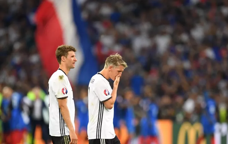 Germany's midfielder Thomas Mueller and midfielder Bastian Schweinsteiger leave the pitch after loosing 2-0 to France in the Euro 2016 semi-final football match between Germany and France at the Stade Velodrome in Marseille on July 7, 2016.
France will face Portugal in the Euro 2016 finals on July 10, 2016. / AFP PHOTO / PATRIK STOLLARZ