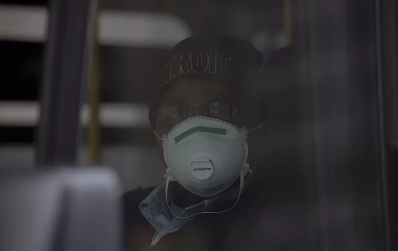A bus driver for DDOT bus line in Detroit, Michigan poses for a portrait while wearing her protective mask on March, 24, 2020. - At 12:01 am Tuesday March 24,2020 Governor Gretchen Whitmer ordered a 'Stay at Home and Stay Safe Order' to slow the spread of Coronavirus (COVID-19) across the State of Michigan which now has 1,791 confirmed cases and 24 deaths due to the virus. (Photo by SETH HERALD / AFP)