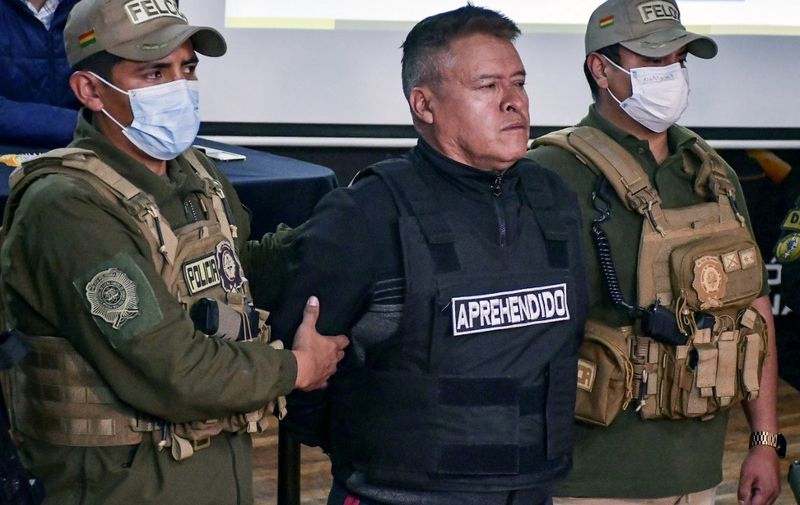 Bolivian now-dismissed army chief General Juan Jose Zuniga (C) is escorted by policemen following his arrest, after he led a military movement which attempted to seize the government palace by force, in La Paz, on June 26, 2024. Two Bolivian army leaders have been arrested after soldiers and tanks took up position on the eve in Plaza Murillo, the historic square where the presidency and Congress are situated, in what President Luis Arce called an attempted coup. (Photo by Daniel MIRANDA / AFP)