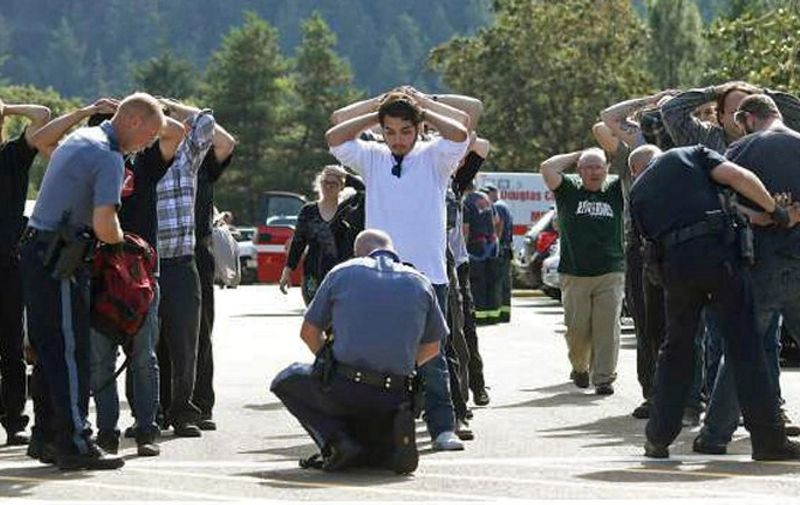 Police officers search students outside Umpqua Community College in Roseburg, Oregon, after a shooting on October 1, 2015. Local media have quoted Oregon State Police Lieutenant Bill Fugate as saying between seven and 10 people were killed and at least 20 injured. A 20-year-old shooter has been confirmed dead after a shoot-out with police, officials said.   = RESTRICTED TO EDITORIAL USE - MANDATORY CREDIT "AFP PHOTO / Michael Sullivan / The News-Review" - NO MARKETING NO ADVERTISING CAMPAIGNS - DISTRIBUTED AS A SERVICE TO CLIENTS =