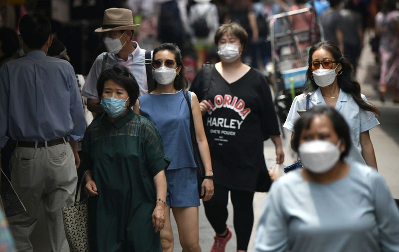 Pedestrians wearing face masks walk through a market in central Seoul on June 23, 2020. - South Korea reported 46 new coronavirus cases on June 23 after health authorities declared the country was battling a second wave of infections that had been circulating for weeks. (Photo by Jung Yeon-je / AFP)