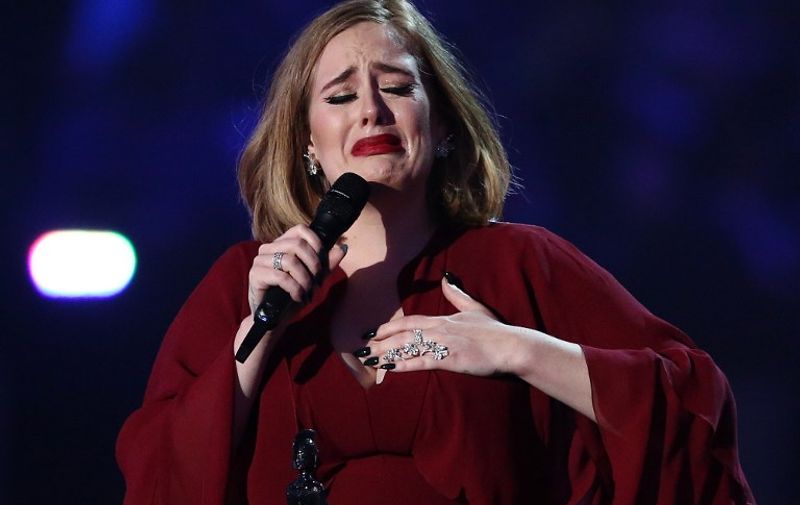 British singer Adele reacts after receiving the Global Success award during the BRIT Awards 2016 in London on February 24, 2016. / AFP PHOTO / JUSTIN TALLIS / RESTRICTED TO EDITORIAL USE, TO ILLUSTRATE THE EVENT AS SPECIFIED IN THE CAPTION  NO POSTERS  NO USE IN MONOGRAPHS