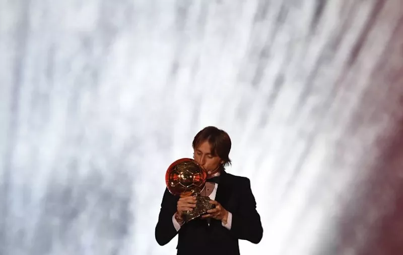 Real Madrid's Croatian midfielder Luka Modric kisses the trophy after receiving the 2018 FIFA Men's Ballon d'Or award for best player of the year during the 2018 FIFA Ballon d'Or award ceremony at the Grand Palais in Paris on December 3, 2018. - The winner of the 2018 Ballon d'Or will be revealed at a glittering ceremony in Paris on December 3 evening, with Croatia's Luka Modric and a host of French World Cup winners all hoping to finally end the 10-year duopoly of Cristiano Ronaldo and Lionel Messi. (Photo by FRANCK FIFE / AFP)