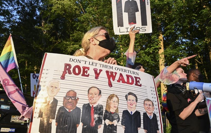 Demonstrators protest at the entrance of the gated community where US Supreme Court Justice Thomas Clarence lives in Fairfax, Virginia, after the US Supreme Court striked down the right to abortion on June 24, 2022. (Photo by ROBERTO SCHMIDT / AFP)