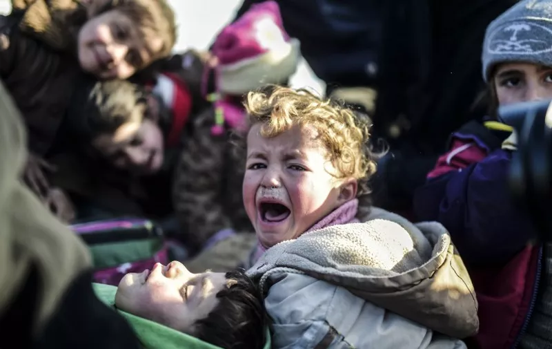 A Syrian child cries as Syrians fleeing the northern embattled city of Aleppo wait on February 5, 2016 in Bab-Al Salama, next to the city of Azaz near Turkish crossing gate in northern Syria. 
Nearly 40,000 Syrian civilians have fled a regime offensive near Aleppo, a monitor said, as Turkey warned it was bracing for a wave of tens of thousands of refugees. / AFP / BULENT KILIC