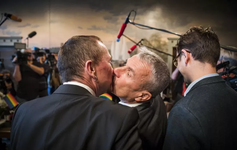 Bode Mende (C) and Karl Kreile kiss after becoming Germany's first gay couple to be legally married as they tied the knot at the Schoeneberg town hall in Berlin on October 1, 2017. - Germany celebrates its first gay marriages as same-sex unions become legal after decades of struggle.
Local authorities rushed to get weddings underway as soon as possible, after lawmakers voted on June 30th to give Germany's roughly 94,000 same-sex couples the right to marry. (Photo by Odd ANDERSEN / AFP)