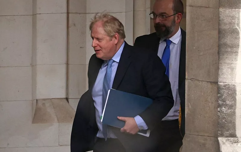Former British Prime Minister Boris Johnson (L) walks through the Parliamentary Estate on his way to Portcullis House in central London on March 22, 2023, to attend Parliament's Privileges Committee hearing. Britain's former prime minister Boris Johnson re-entered the bear pit of parliamentary inquisition on Wednesday for a grilling about "Partygate" that could decide his political future. (Photo by ADRIAN DENNIS / AFP)