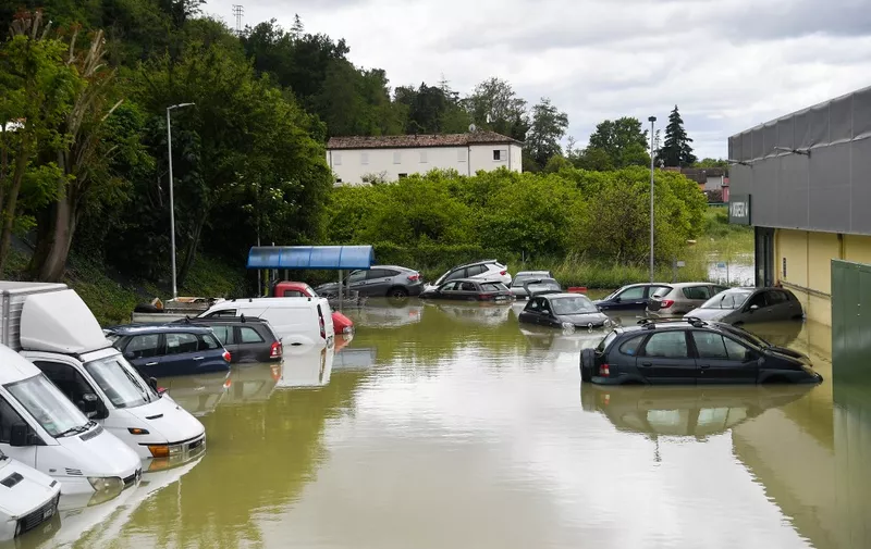 A general view shows vans and cars on a flooded supermarket parking lot, caused by the flooding of the river Savio in the Ponte Vecchio district of Cesena, central eastern Italy, on May 17, 2023. Trains were stopped and schools were closed in many towns while people were asked to leave the ground floors of their homes and to avoid going out, and five people have died after the floodings across Italy's northern Emilia Romagna region. (Photo by Alessandro SERRANO / AFP)