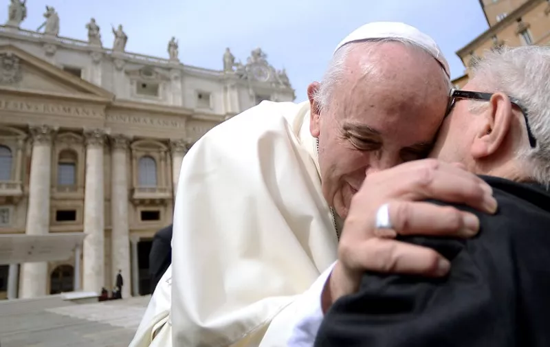Pope Francis (L) hugs a faithfull in St Peter's square at the Vatican on September 9, 2015, after his weekly general audience. In a letter to believers on September 8, the Argentinian pontiff said annulments would require approval by only one church tribunal, rather than two as currently. A streamlined procedure is to be introduced for the most straightforward cases and access to hearings will not cost anything, the letter states. AFP PHOTO / FILIPPO MONTEFORTE