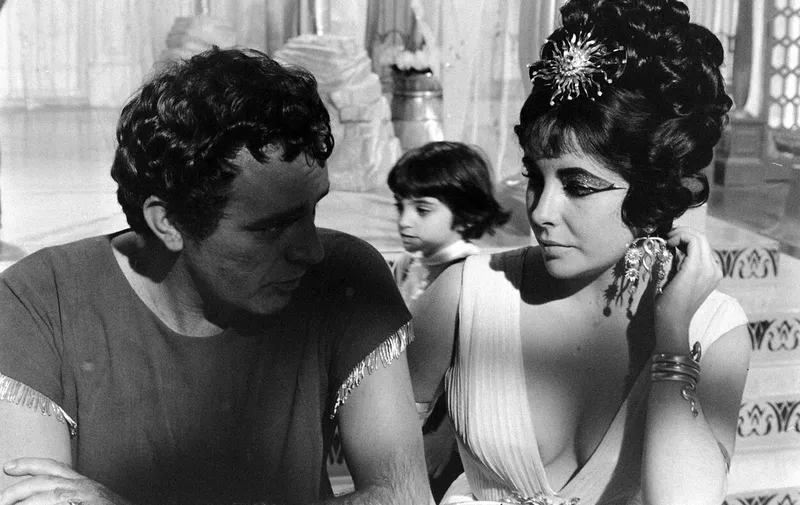 1963 American epic historical drama film directed by Joseph L. Mankiewicz, with a screenplay adapted by Mankiewicz, Ranald MacDougall and Sidney Buchman from the book The Life and Times of Cleopatra by Carlo Maria Franzero, and from histories by Plutarch, Suetonius, and Appian. It stars Elizabeth Taylor in the eponymous role. Richard Burton, Rex Harrison, Roddy McDowall, and Martin Landau are featured in supporting roles. It chronicles the struggles of Cleopatra, the young Queen of Egypt, to resist the imperial ambitions of Rome.
Hollywood Photo Archive,Image: 586960425, License: Rights-managed, Restrictions: , Model Release: no, Credit line: Profimedia