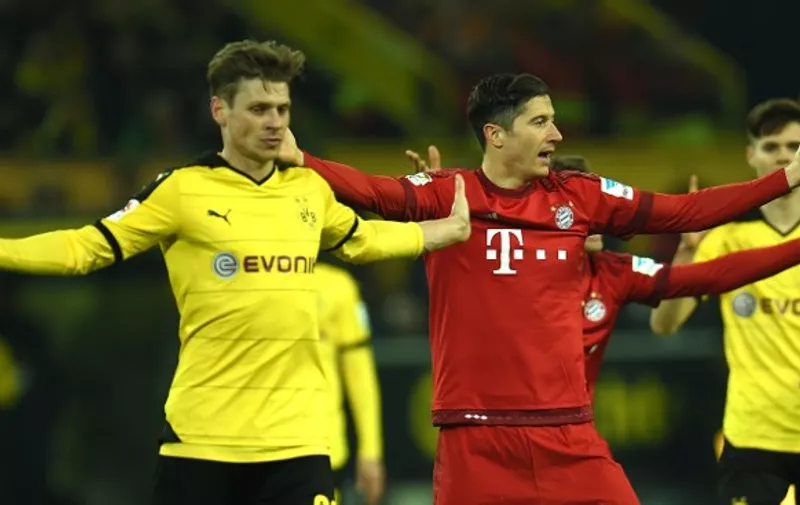 Dortmund's Polish defender Lukasz Piszczek (L) and Bayern Munich's Polish striker Robert Lewandowski react during the German first division Bundesliga football match of Borussia Dortmund v FC Bayern Muenchen in Dortmund, on March 5, 2016. / AFP / PATRIK STOLLARZ / RESTRICTIONS: DURING MATCH TIME: DFL RULES TO LIMIT THE ONLINE USAGE TO 15 PICTURES PER MATCH AND FORBID IMAGE SEQUENCES TO SIMULATE VIDEO. == RESTRICTED TO EDITORIAL USE == FOR FURTHER QUERIES PLEASE CONTACT DFL DIRECTLY AT + 49 69 650050