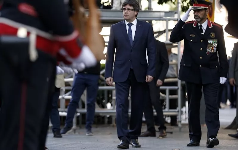 President of the Catalan regional government Carles Puigdemont (C) and Josep Lluis Trapero (R), chief of the Catalan regional police, attend a ceremony at the Rafael de Casanovas monument in Barcelona on September 11, 2017 in Barcelona during the National Day of Catalonia, the "Diada."
Hundreds of thousands of Catalans were expected to rally to demand their region break away from Spain, in a show of strength three weeks ahead of a secession referendum banned by Madrid. The protest coincides with Catalonia's national day, the "Diada," which commemorates the fall of Barcelona in the War of the Spanish Succession in 1714 and the region's subsequent loss of institutions and freedoms.
 / AFP PHOTO / PAU BARRENA