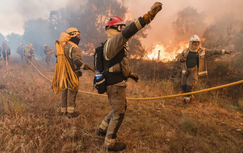 Firefighters operate at the site of a wildfire in Pumarejo de Tera near Zamora, northern Spain, on June 18, 2022. - Firefighters continued to fight against multiple fires in Spain, one of which ravaged nearly 20,000 hectares of land, on the last day of an extreme heat wave which crushed the country, with peaks at 43 degrees. The largest of these forest fires was still out of control this afternoon in the Sierra de la Culebra, a mountain range in the region of Castile and Leon (northwest), near the border with Portugal. (Photo by CESAR MANSO / AFP)