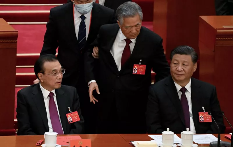 China's President Xi Jinping (R) sits besides Premier Li Keqiang (L) as former president Hu Jintao (C) is assisted to leave from the closing ceremony of the 20th China's Communist Party's Congress at the Great Hall of the People in Beijing on October 22, 2022. (Photo by Noel Celis / AFP)