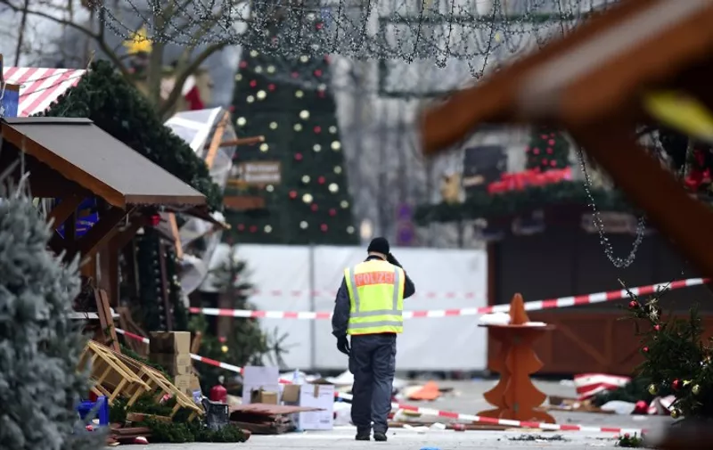 A policeman walks at the Christmas market near the Kaiser-Wilhelm-Gedaechtniskirche (Kaiser Wilhelm Memorial Church), the day after a terror attack, in central Berlin, on December 20, 2016.
German police said they were treating as "a probable terrorist attack" the killing of 12 people when the speeding lorry cut a bloody swath through the packed Berlin Christmas market. / AFP PHOTO / Tobias SCHWARZ