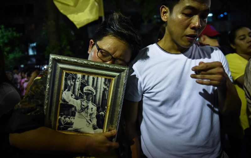 People react to the death of Thailand's King Bhumibol Adulyadej at Siriraj Hospital in Bangkok on October 13, 2016.
Thailand's King Bhumibol Adulyadej has died after a long illness, the palace announced on October 13, 2016, ending a remarkable seven-decade reign and leaving a divided people bereft of a towering and rare figure of unity. / AFP PHOTO / LILLIAN SUWANRUMPHA
