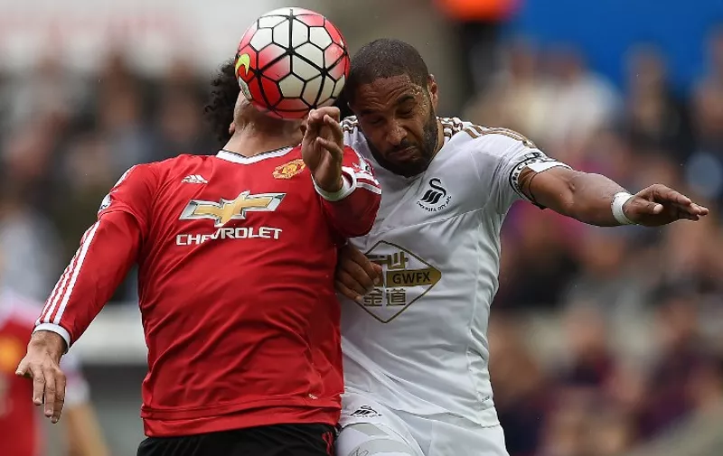 Manchester United's Belgian midfielder Marouane Fellaini (L) vies against Swansea City's English-born Welsh defender Ashley Williams during the English Premier League football match between Swansea City and Manchester United at The Liberty Stadium in Swansea, south Wales on August 30, 2015. Swansea won the match 2-1.   AFP PHOTO / PAUL ELLIS

RESTRICTED TO EDITORIAL USE. No use with unauthorized audio, video, data, fixture lists, club/league logos or 'live' services. Online in-match use limited to 75 images, no video emulation. No use in betting, games or single club/league/player publications.