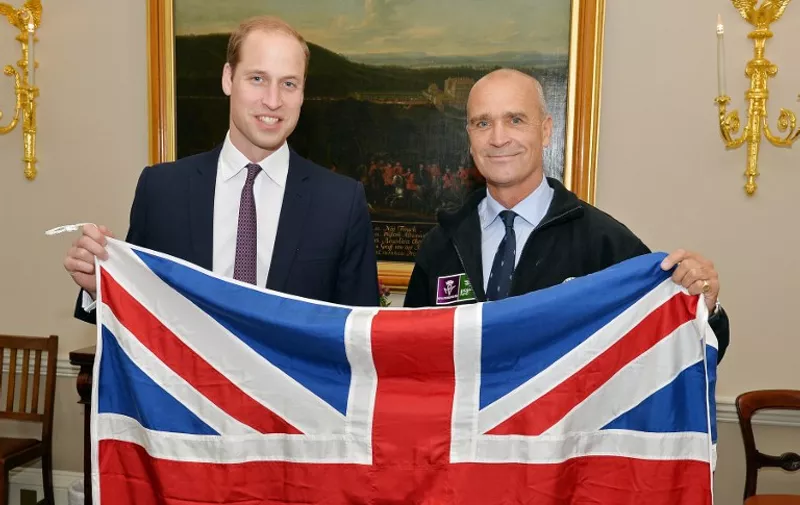 Britain's Prince William, Duke of Cambridge, (L) and polar explorer Henry Worsley, pose with a Union flag at Kensington Palace in London on October 19, 2015. Worsley will undertake the 2015/16 Shackleton solo challenge starting in November, and attempting to undertake Sir Ernest Shackleton's unfinished journey to the South Pole from the Weddell Sea.   AFP PHOTO / JOHN STILLWELL / POOL / AFP / JOHN STILLWELL