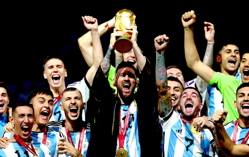 Soccer Football - FIFA World Cup Qatar 2022 - Final - Argentina v France - Lusail Stadium, Lusail, Qatar - December 18, 2022
Argentina's Lionel Messi lifts the World Cup trophy alongside teammates as they celebrate after winning the World Cup REUTERS/Kai Pfaffenbach