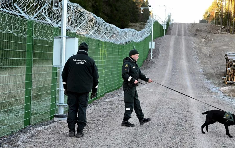 Members of the Finnish Border Guard agency (RAJA) with dog patrol along a section of the pilot border fence during a press visit to the Finnish-Russian border in Imatra, Finland on October 26, 2023. Finland's border guard builds a 200-kilometre-long border fence with Russia after Moscow invaded Ukraine last year. (Photo by Jussi Nukari / Lehtikuva / AFP) / Finland OUT