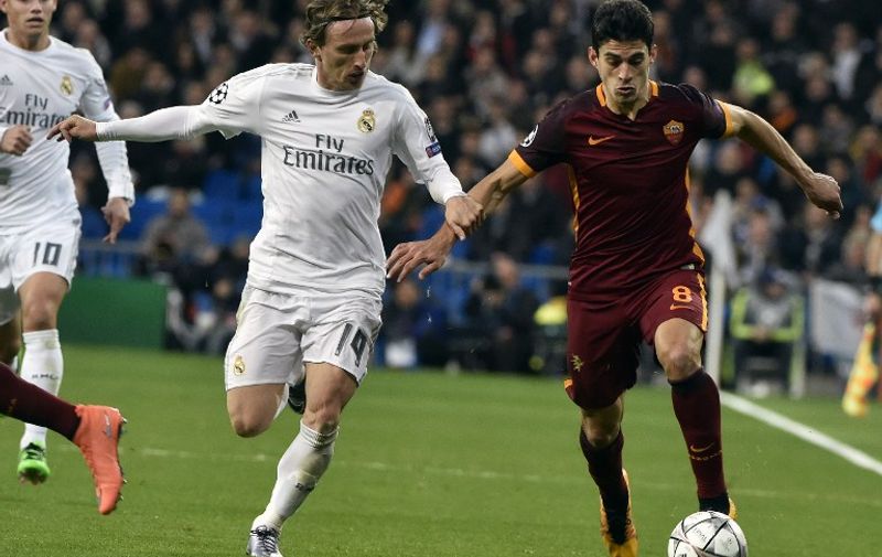Real Madrid's Croatian midfielder Luka Modric (L) vies with Roma's midfielder Diego Perotti during the UEFA Champions League round of 16, second leg football match Real Madrid FC vs AS Roma at the Santiago Bernabeu stadium in Madrid on March 8, 2016. / AFP / GERARD JULIEN