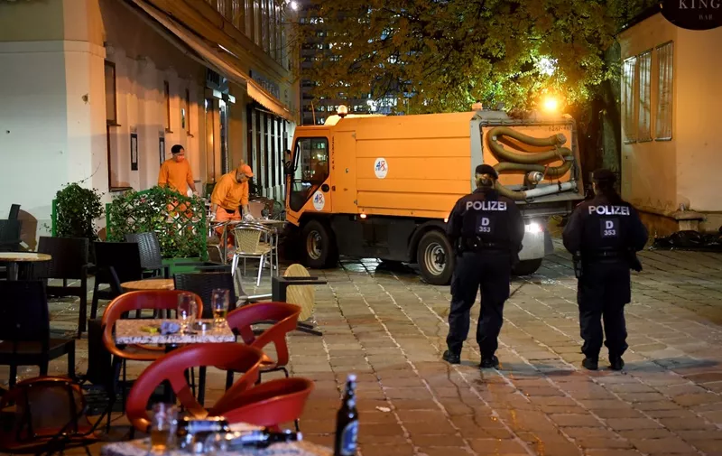 Hastily left drinks are seen on a table as cleaning crews and police work outside a restaurant near the scene of an attack in Vienna, Austria on November 3, 2020, one day after a shooting at multiple locations across central Vienna. A huge manhunt was under way after gunmen opened fire at multiple locations across central Vienna in the evening of November 2, 2020, killing at least four people in what Austrian Chancellor Sebastian Kurz described as a "repulsive terror attack". (Photo by HELMUT FOHRINGER / APA / AFP) / Austria OUT