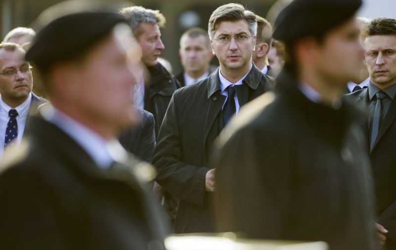 Croatian Prime Minister Andrej Plenkovic (C) looks on during a ceremony marking the beginning of the burial of remains of some 800 people killed by communist forces after World War II at the Dobrava Memorial Park in Maribor, on October 27, 2016. / AFP PHOTO / Jure MAKOVEC
