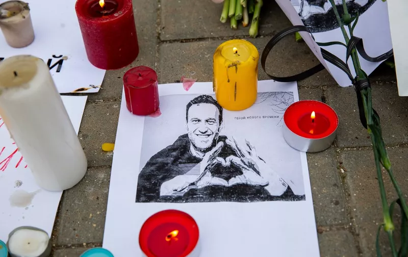 Candles surround a portrait of Alexei Navalny at Russian embassy in Chisinau on February 17, 2024, one day after Russian officials announced the death of the Kremlin's most prominent critic. Russian officials announced the 47-year-old had died on February 16 in an Arctic prison, a month before an election poised to extend President Vladimir Putin's hold on power. (Photo by Elena COVALENCO / AFP)