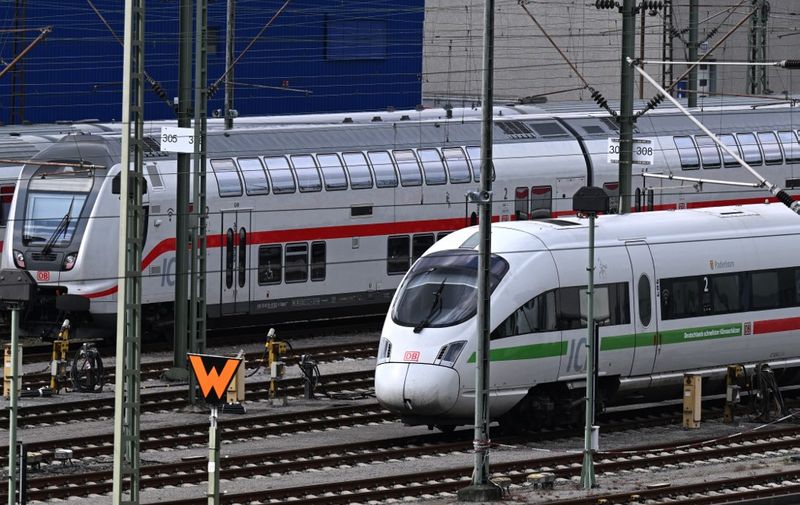 An ICE Inter City Express train (R) of German railway operator Deutsche Bahn (DB) and IC Inter City train stand on sidings at a depot in Dortmund, western Germany on August 8, 2023. (Photo by Ina FASSBENDER / AFP)