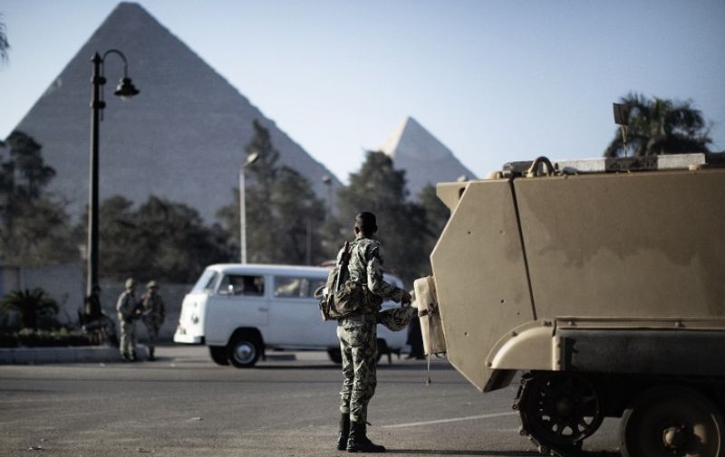Egyptian army soldiers take position in front of the Giza pyramids in Cairo on January 31, 2011 as Egyptian protesters called for an indefinite strike in Egypt upping the stakes in their bid to topple President Hosni Mubarak's regime.   AFP PHOTO/MARCO LONGARI