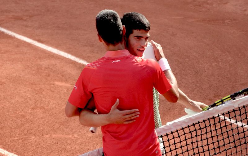 Serbia's Novak Djokovic, left, is hugged by Spain's Carlos Alcaraz after Djokovic won the semifinal match of the French Open tennis tournament in four sets, 6-3, 5-7, 6-1, 6-1, at the Roland Garros stadium in Paris, Friday, June 9, 2023. (AP Photo/Christophe Ena)