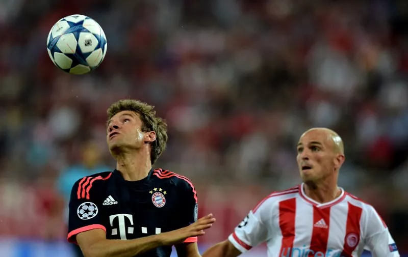 Bayern Munich's German forward Thomas Mueller (L) fights for the ball with Olympiacos' Argentinian midfielder Esteban Cambiasso during their Group F UEFA Champions League football match between Olympiakos and Bayern Munich at the Karaiskaki stadium in Piraeus, near Athens on September 16, 2015. AFP PHOTO / ARIS MESSINIS