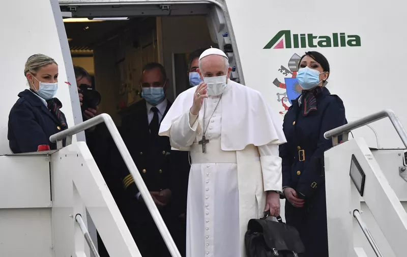 Pope Francis waves as he boards a plane to depart to Iraq on March 5, 2021 at Rome's Fiumicino airport. - Defying security fears and the pandemic to comfort one of the world's oldest and most persecuted Christian communities, the 84-year-old pontiff starts on February 5 a 4-day visit to Iraq as a "pilgrim of peace", and will reach out to Shiite Muslims when he meets Iraq's top cleric, Grand Ayatollah Ali Sistani. (Photo by Andreas SOLARO / AFP)