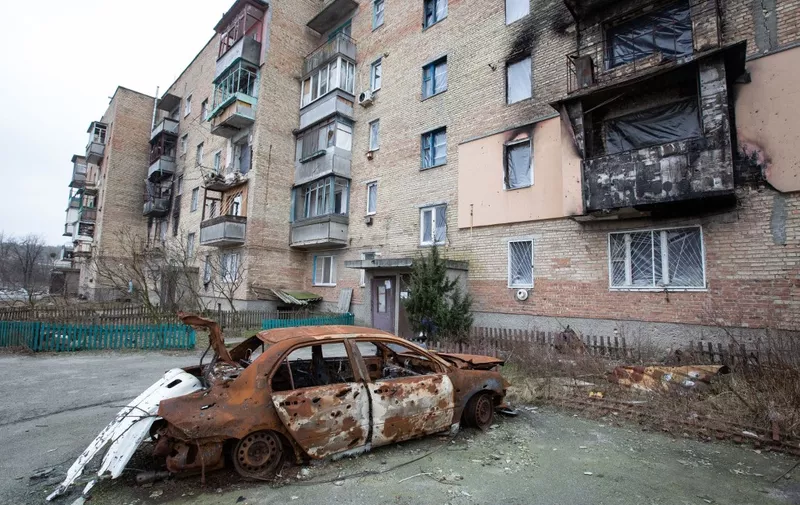 KYIV REGION, UKRAINE - JANUARY 24: A wrecked car is seen in front of the damaged residential building in the village of Gorenka, which was heavily damaged by the clashes between the Russian and Ukrainian armies in Kyiv Region, Ukraine on January 24, 2023. Oleksii Chumachenko / Anadolu Agency (Photo by Oleksii Chumachenko / ANADOLU AGENCY / Anadolu Agency via AFP)