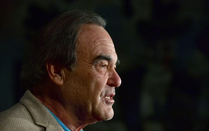 US director Oliver Stone speaks to reporters as he arrives for a reception for the Cinema for Peace Foundation on February 12, 2017 in Berlin. / AFP PHOTO / John MACDOUGALL
