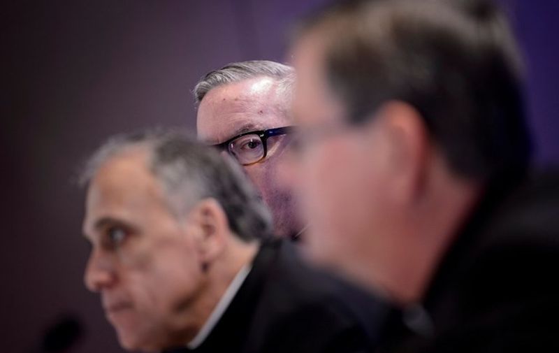 Burlington Bishop Christopher Coyne (C) looks at Galveston-Houston Cardinal Daniel DiNardo (L), President of the USCCB General Assembly, and Indiana Bishop Timothy Doherty, chairman of the committee for the Protection of Children and Young People, during a press conference at the annual US Conference of Catholic Bishops November 12, 2018 in Baltimore, Maryland. (Photo by Brendan Smialowski / AFP)