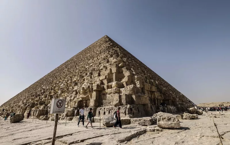 Tourists visit the Great Pyramid of Khufu (Cheops) at the Giza Pyramids necropolis on the southwestern outskirts of Cairo, on March 2, 2023. - A hidden corridor of 9 metres long has been spotted close to the main entrance of the pyramid, a discovery made under the Scan Pyramids project that has been in place since 2015, Egyptian antiquities officials announced on March 2. (Photo by Khaled DESOUKI / AFP) / The erroneous mention[s] appearing in the metadata of this photo by Khaled DESOUKI has been modified in AFP systems in the following manner: [March 2] instead of [February 2]. Please immediately remove the erroneous mention[s] from all your online services and delete it (them) from your servers. If you have been authorized by AFP to distribute it (them) to third parties, please ensure that the same actions are carried out by them. Failure to promptly comply with these instructions will entail liability on your part for any continued or post notification usage. Therefore we thank you very much for all your attention and prompt action. We are sorry for the inconvenience this notification may cause and remain at your disposal for any further information you may require.