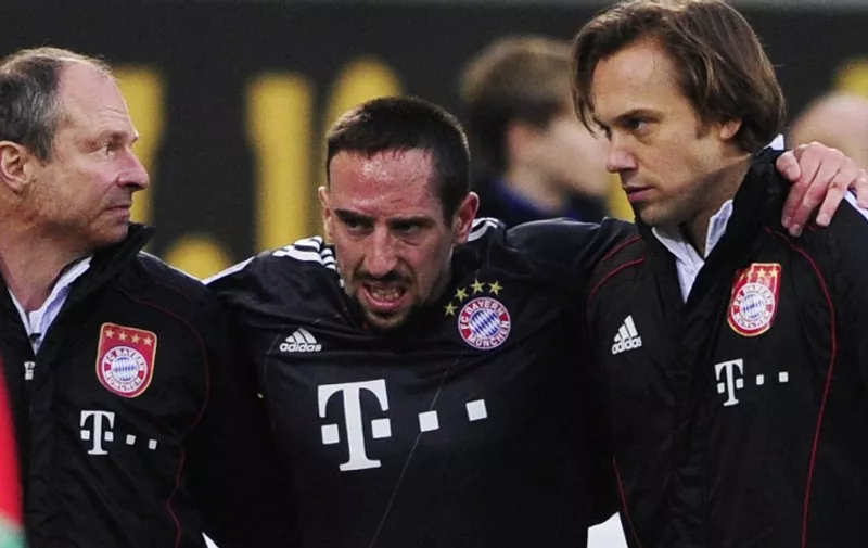 FILES - Picture taken on January 15, 2011shows Bayern Munich's French midfielder Franck Ribery (C) helped off the pitch after sustaining an injury during the German first division Bundesliga football match VfL Wolfsburg vs Bayern Munich in the northern German city of Wolfsburg. Ribery looks set to be out until at least mid-February after suffering a relapse as his knee injury takes longer to heal than first expected, it was revealed on January 27, 2011. The latest set-back means Ribery is set to miss France's friendly with Brazil on February 9 in Paris.   AFP PHOTO / JOHN MACDOUGALL