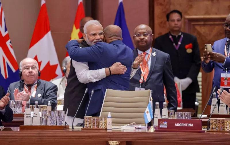 African Union Chairman and Comoros President Azali Assoumani (R) and India's Prime Minister Narendra Modi hug each other during the first session of the G20 Leaders' Summit at the Bharat Mandapam in New Delhi on September 9, 2023. (Photo by Ludovic MARIN / POOL / AFP)