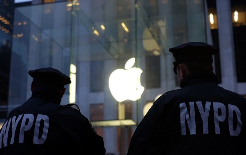 Two New York Police Department (NYPD) officers stand guard near the Apple store on Fifth Avenue in New York during an anti-government demonstration on February 23, 2016.
Apple is battling the US government over unlocking devices in at least 10 cases in addition to its high-profile dispute involving the iPhone of one of the San Bernardino attackers, court documents show. Apple has been locked in a legal and public relations battle with the US government in the California case, where the FBI is seeking technical assistance in hacking the iPhone of Syed Farook, a US citizen, who with his Pakistani wife Tashfeen Malik in December gunned down 14 people.
 / AFP / Jewel Samad