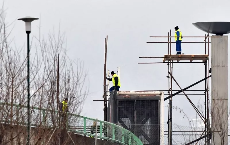 Bosnian workers are working on January 30, 2019 on preparations of Sarajevo's Olympic stadium, built and used during the XIV Winter Olympic Games in 1984, before The European Youth Olympics Festival (EYOF) opening ceremony. - When Sarajevo welcomed the globe's top athletes to its mountains for the 1984 Winter Olympics, it was a moment of pride for all of Yugoslavia. Three decades later, the post-war capital of Bosnia  hopes to rekindle the flame as it hosts the European Youth Olympics form February 9, 2019 to February 16. (Photo by ELVIS BARUKCIC / AFP)