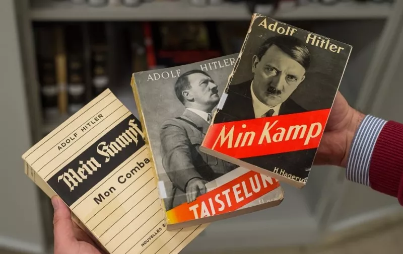 A man holds a French (L), a Finnish (C) and a Danish (R) edition of Adolf Hitler's "Mein Kampf" (My Struggle) at the Institut fuer Zeitgeschichte (Institute for Contemporary History, IFZ) in Munich, southern Germany, on December 3, 2015. For the first time since World War II, Adolf Hitler's "Mein Kampf" will be printed in Germany in January 2016 as an annotated edition, the IFZ institute publishing it said.     AFP PHOTO / DPA / MATTHIAS BALK   +++   GERMANY OUT   +++ / AFP / DPA / MATTHIAS BALK