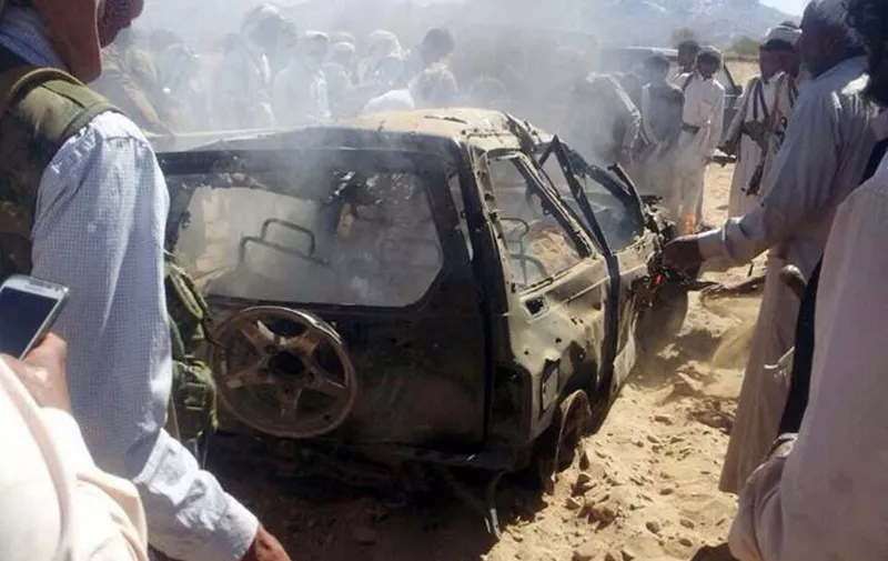 Yemenis gather around a burnt car after it was targeted by a drone strike killing three suspected al-Qaeda militants on January 26, 2015 between the Marib and Chabwa provinces, a desert area east of Sanaa. The drone strike saw an unmanned aircraft, which only the United States operates in the region, fire four missiles at a vehicle killing the three suspected militants, a day after Washington vowed to continue its campaign against the jihadist group despite the Arabian Peninsula country's ongoing political crisis.   AFP PHOTO / STR (Photo by AFP)